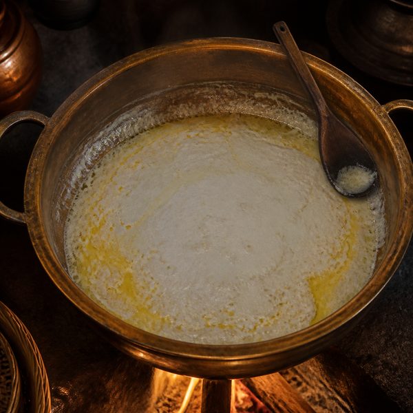 Coconut milk cream being slowly cooked in a traditional vessel